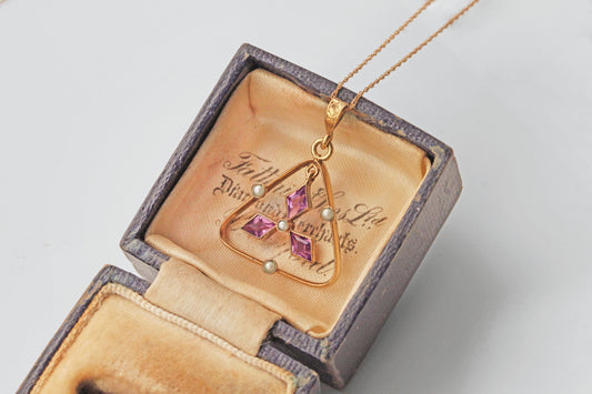 Close up of Edwardian pendant with amethyst paste and seed pearls

