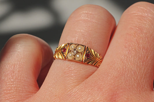Victorian antique pearl diamond and ruby ring in 15ct gold on ring finger