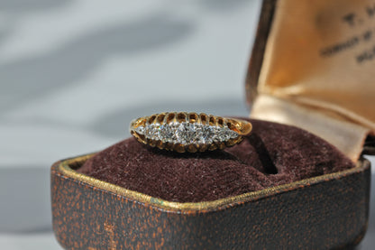 Antique 18ct gold five stone diamond ring displayed on antique jewellery box