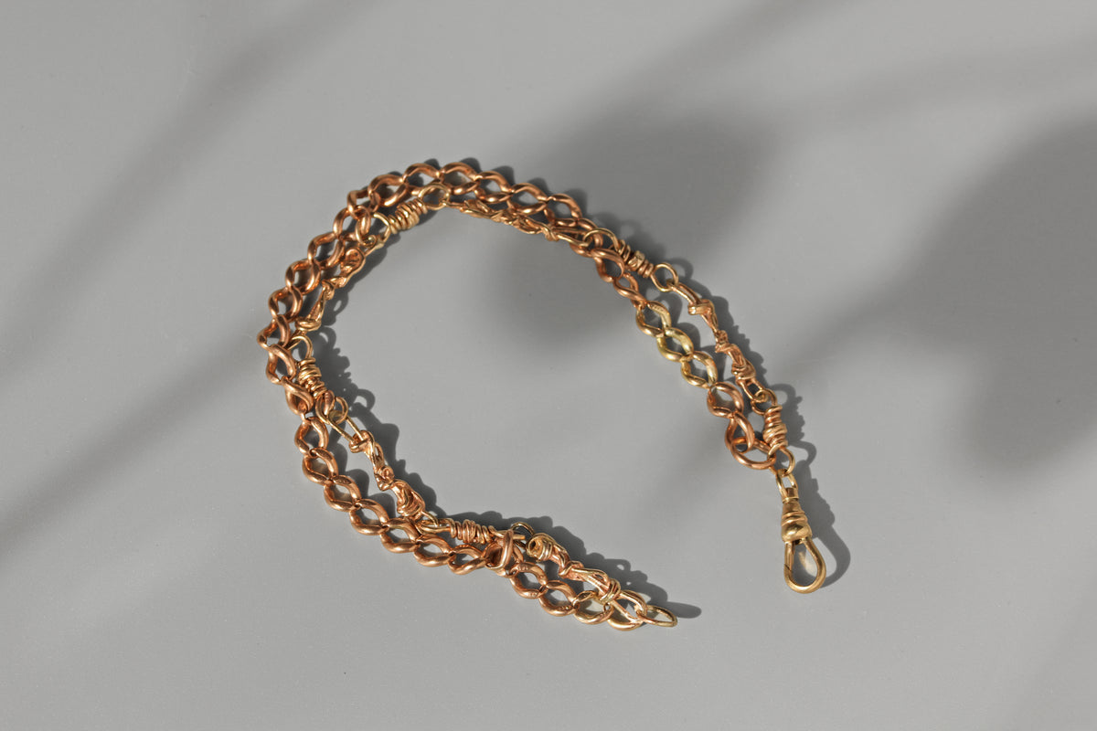 Antique 9ct Albertina style curb link and fancy link men's bracelet with dog clip displayed on grey background in the sunlight