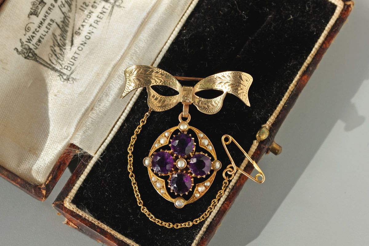 Antique 9ct gold amethyst and pearl bow brooch pendant, with original safety chain displayed in antique box