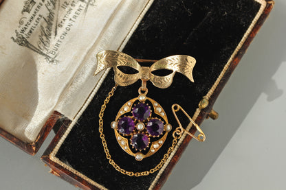 Antique 9ct gold amethyst and pearl bow brooch pendant, with original safety chain displayed in antique box