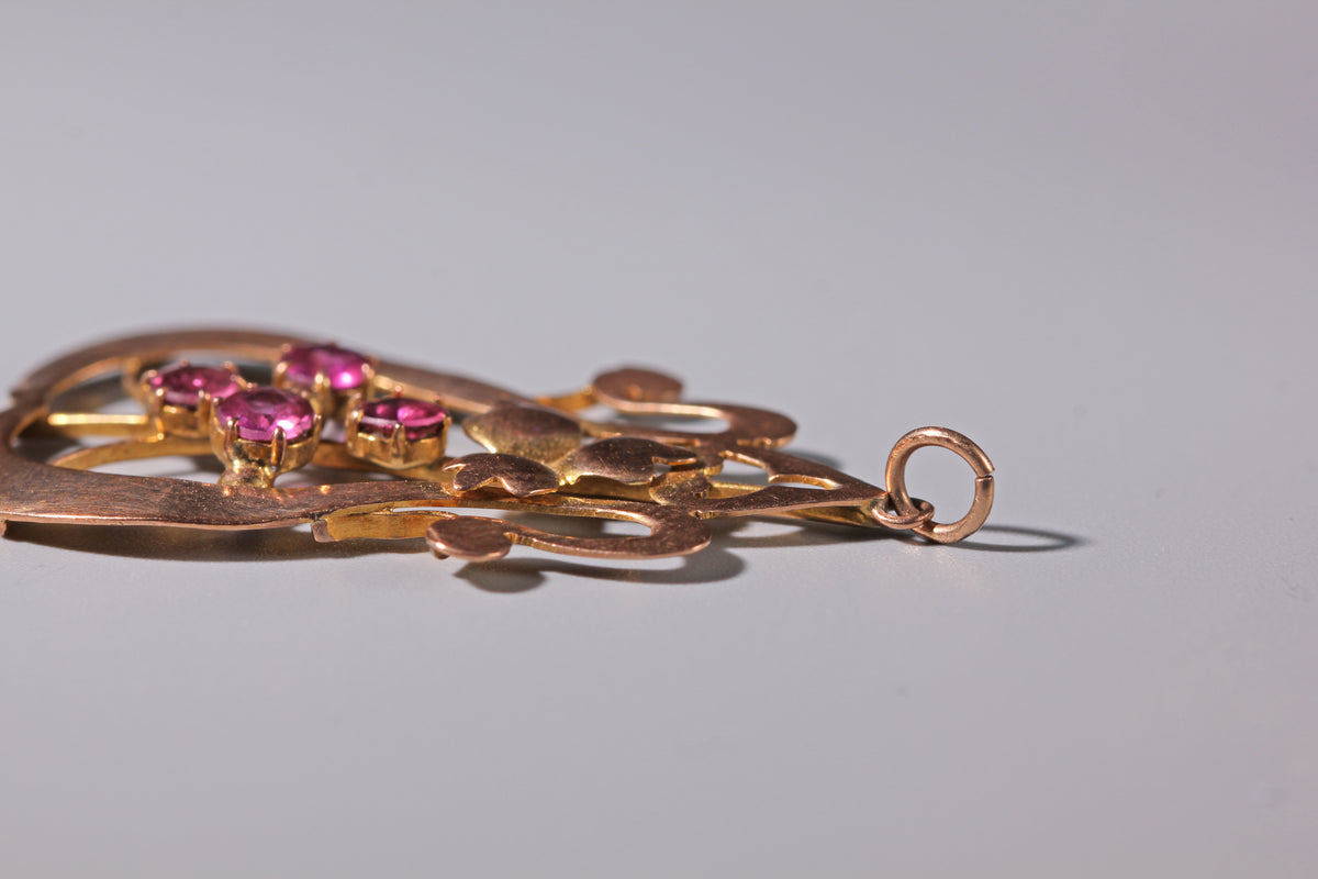 Close up of Edwardian pink tourmaline pendant with stylised ivy leaf detail
