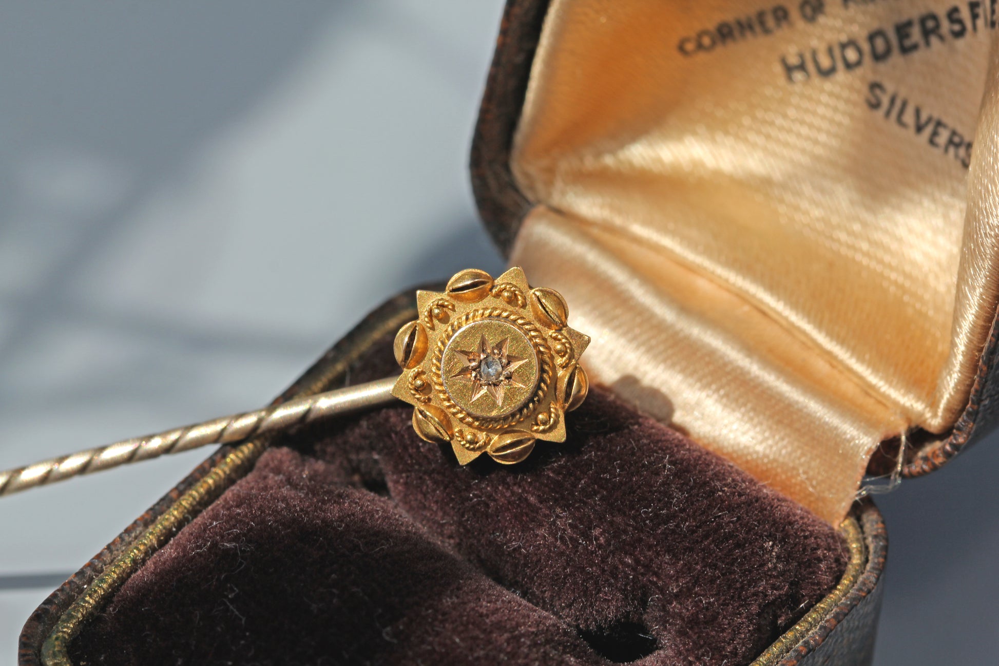 Antique celestial diamond stick pin displayed in a vintage jewellery box
