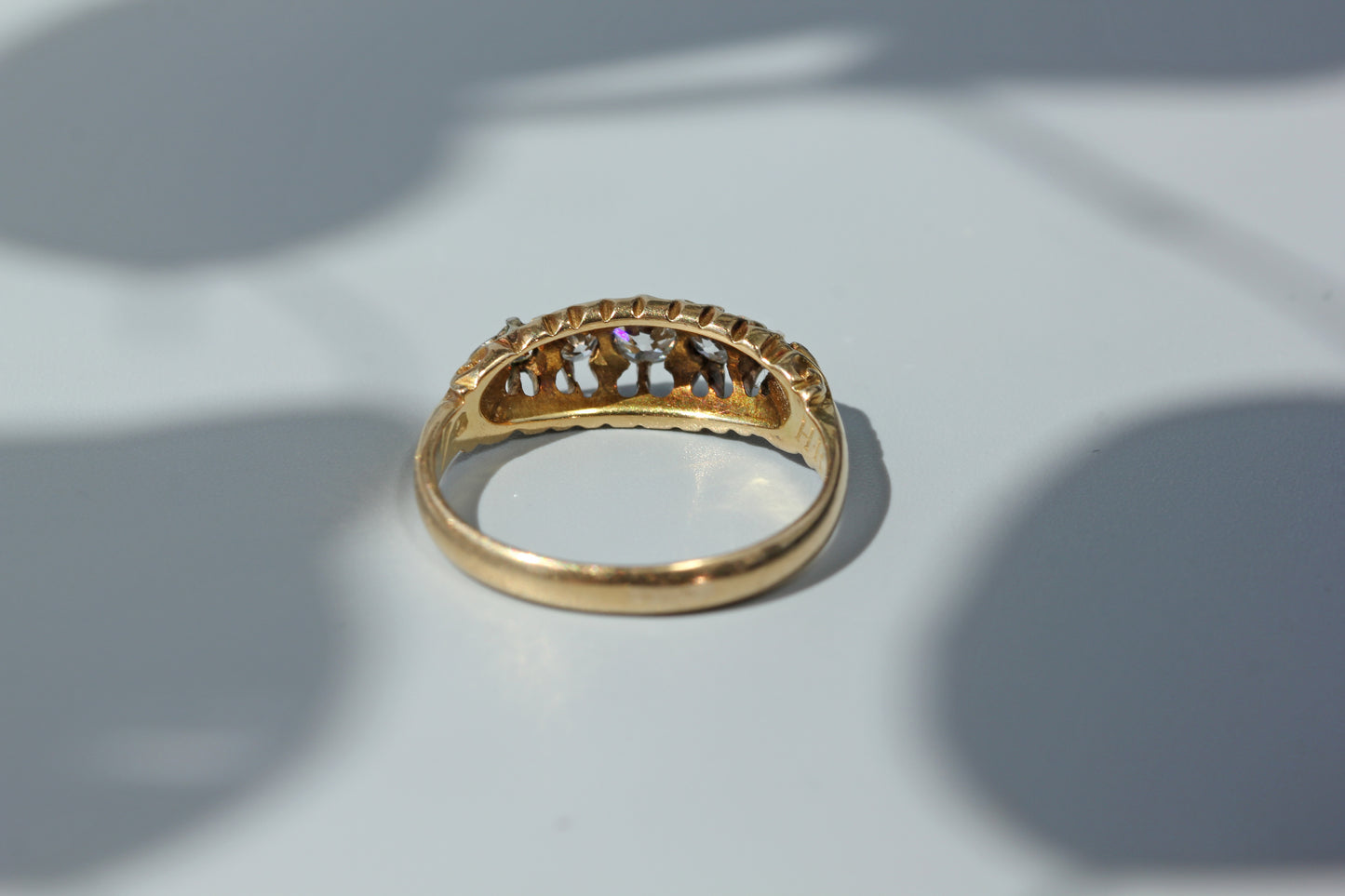 An antique 18ct yellow gold ring, set with five diamonds in an open back gallery