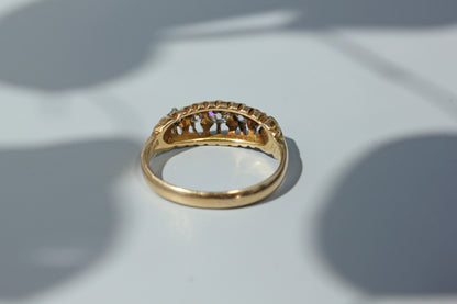 An antique 18ct yellow gold ring, set with five diamonds in an open back gallery