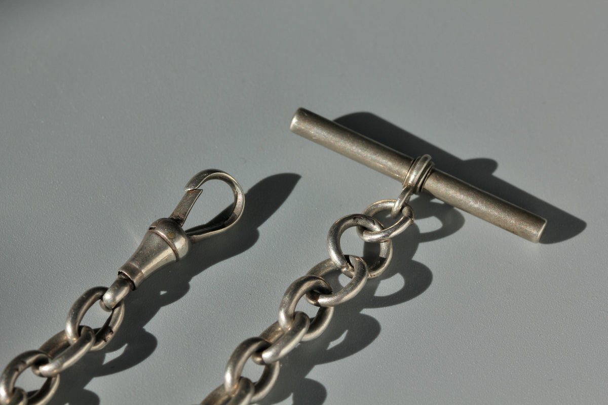 Antique sterling silver dog clip and bar on an Albert watch chain bracelet 