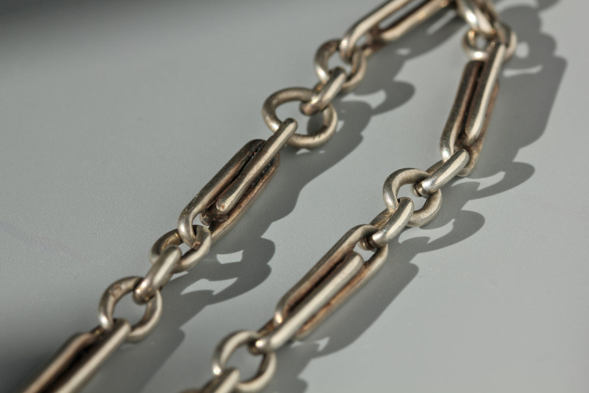 Trombone link details on an antique sterling silver watch chain 