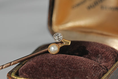 Art deco 18ct gold stick pin with an old cut diamond and pearl in a cherry shaped mount, displayed on antique jewellery box
