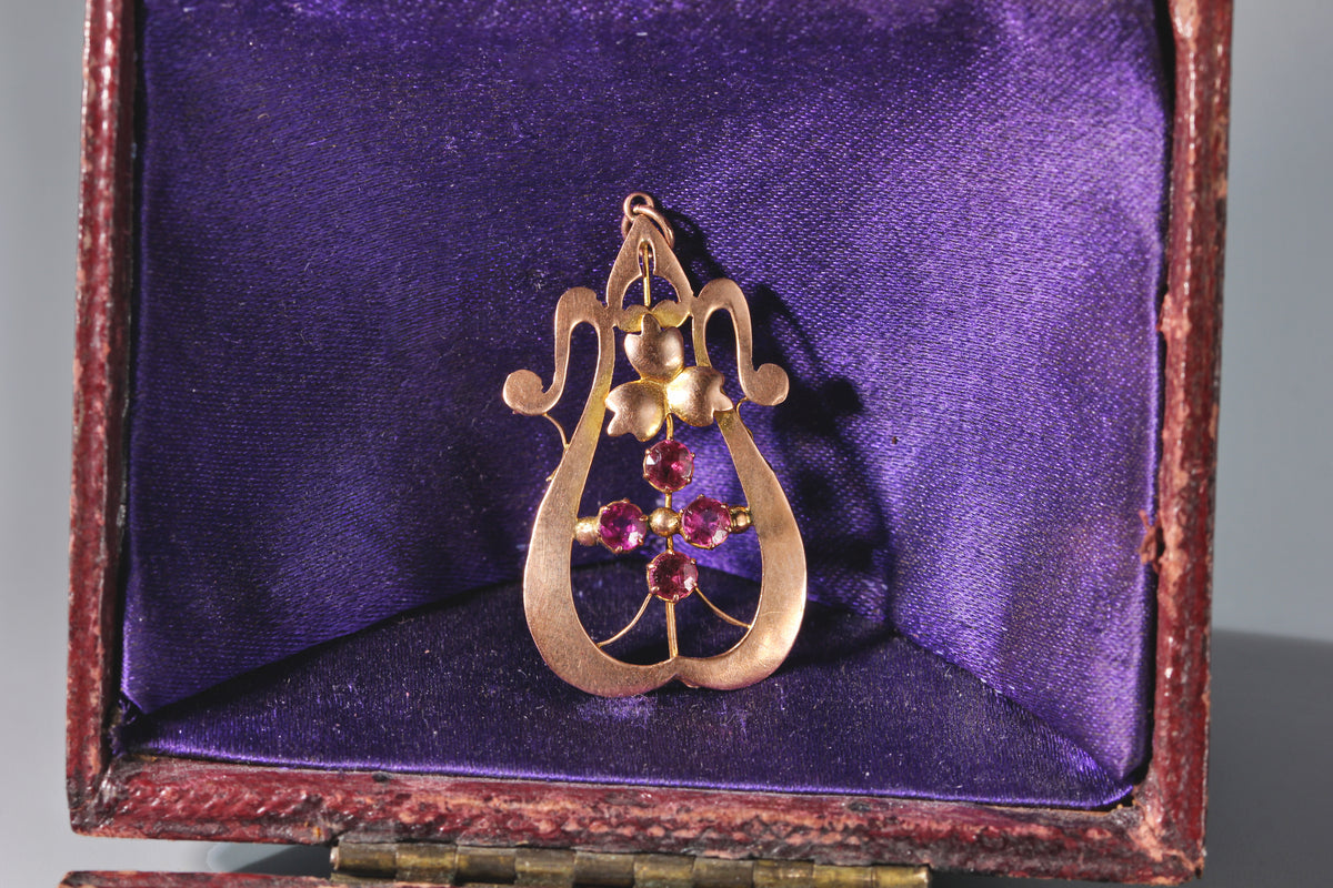 An antique 9ct rose gold floral design pendant with pink tourmaline stones and ivy leaf details