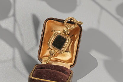 Antique bloodstone fob key pendant with decorative floral accents
