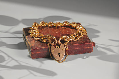 Detailed view of antique gold fancy links and heart padlock fastening
