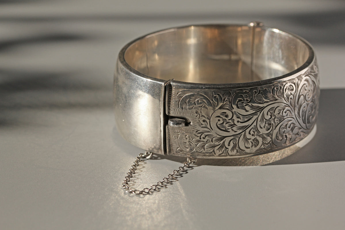 Details of bracelet clasp on vintage sterling silver bangle with etched floral details