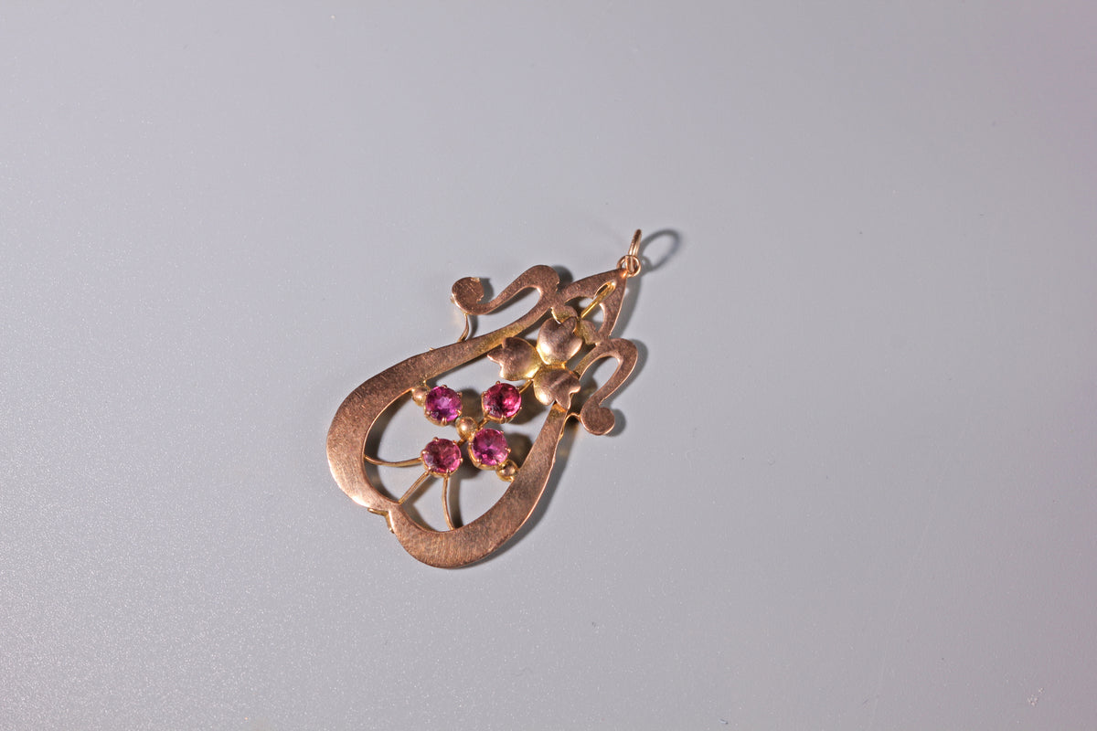 Edwardian 9ct gold pendant with four pink gemstones arranged in a cross
