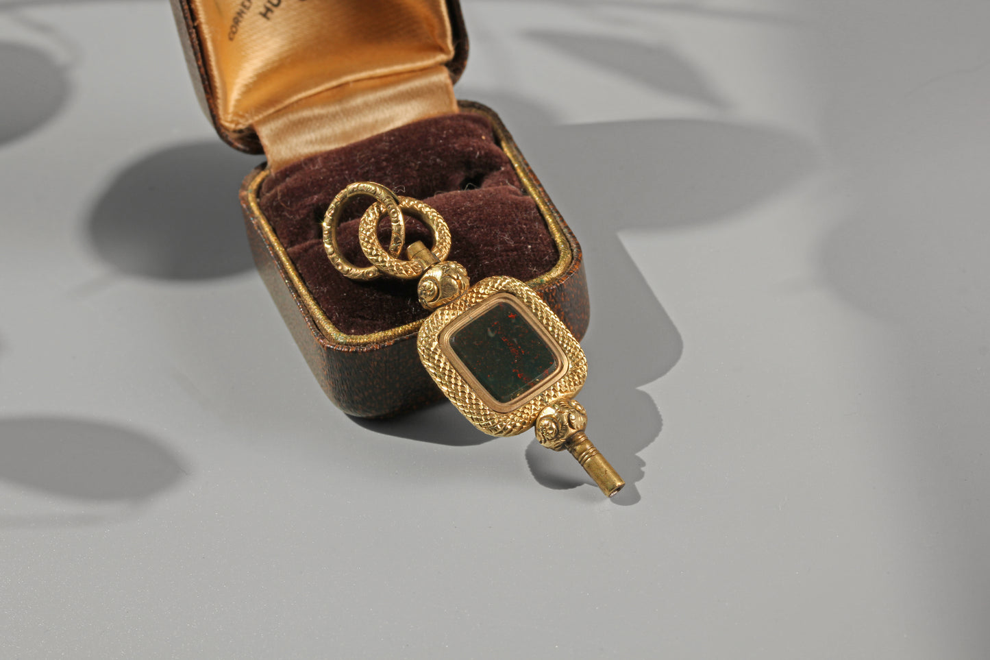 Antique watch key pendant with richly detailed split ring and bloodstone panel
