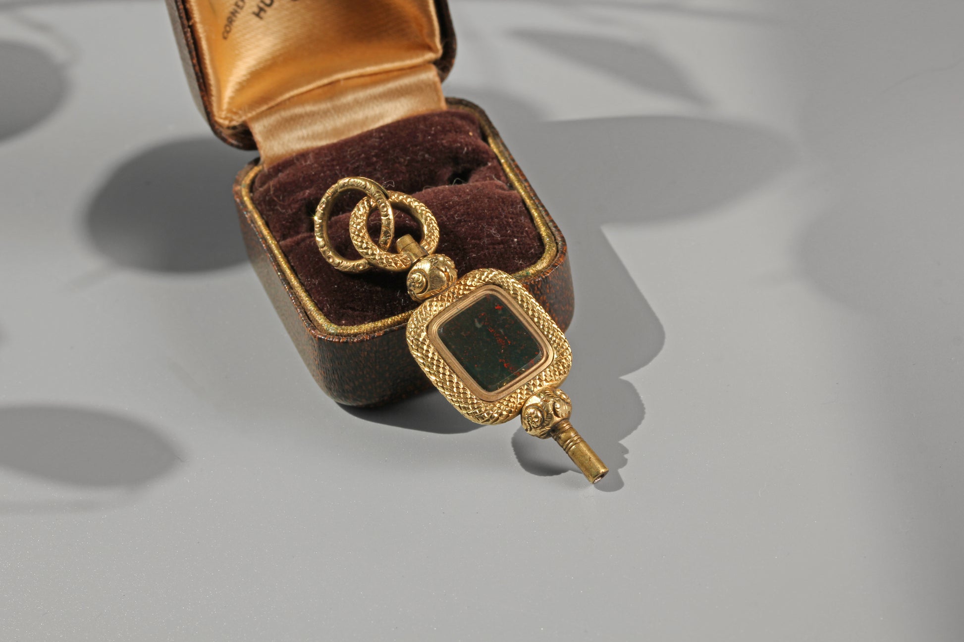 Antique watch key pendant with richly detailed split ring and bloodstone panel
