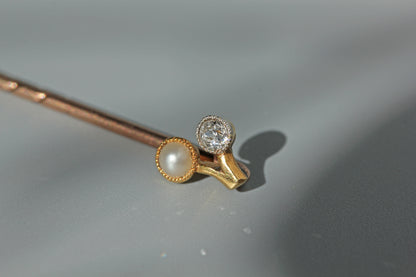 Close up of antique old cut diamond on a 18ct gold stick pin with a pearl