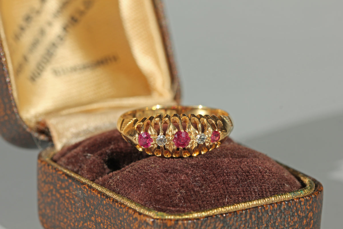An antique gold 18ct boat ring with alternating ruby and diamond stones, in an antique jewellery box 