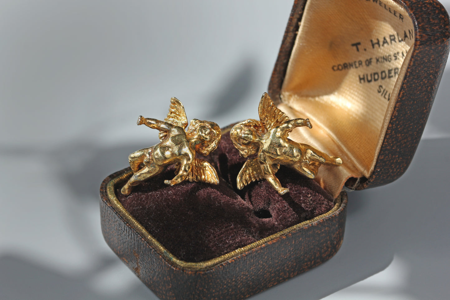 Sculptural winged cherub earrings with antique gold finish

