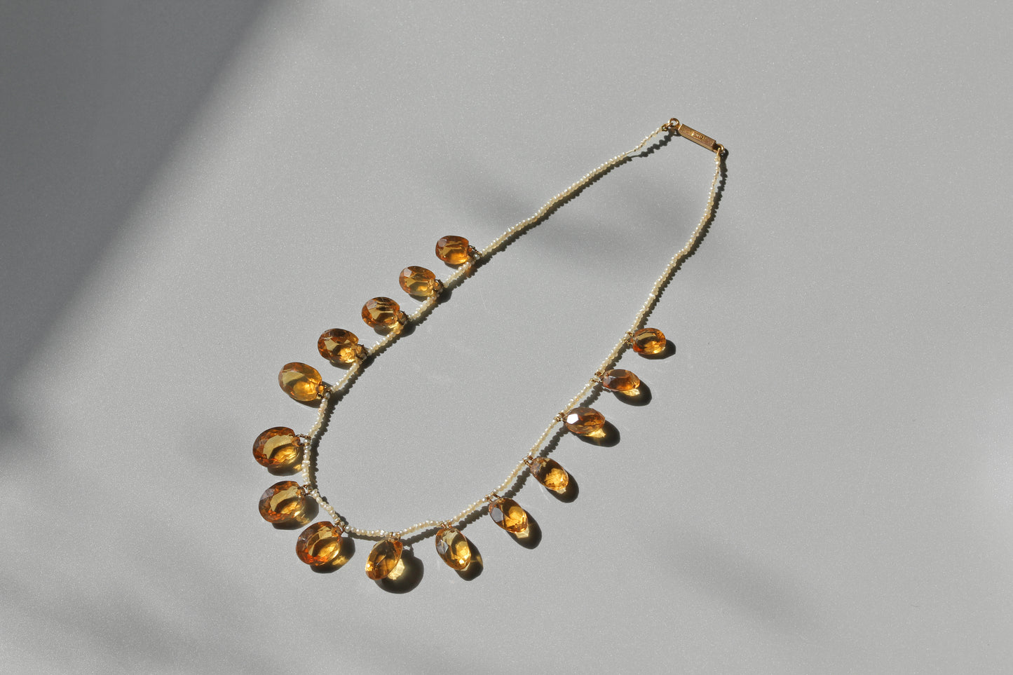 A delicate antique victorian citrine and pearl necklace, with a 15ct gold clasp