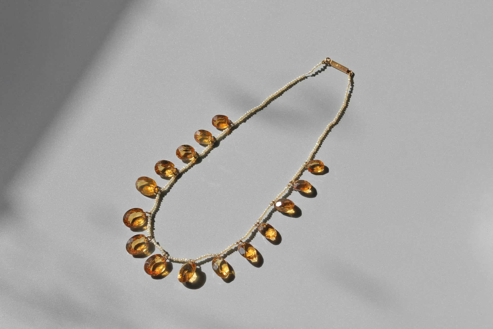 A delicate antique victorian citrine and pearl necklace, with a 15ct gold clasp
