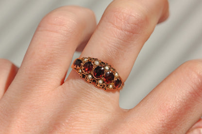Antique garnet and pearl five stone ring in 9 carat gold worn on hand

