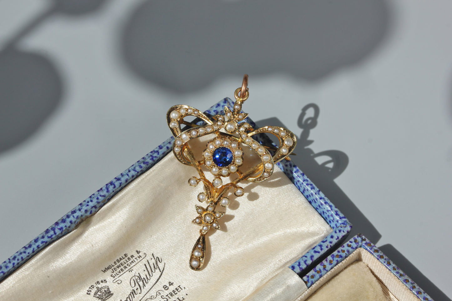 Antique seed pearl lavaliere pendant with cobalt blue paste centre stone in warm gold
