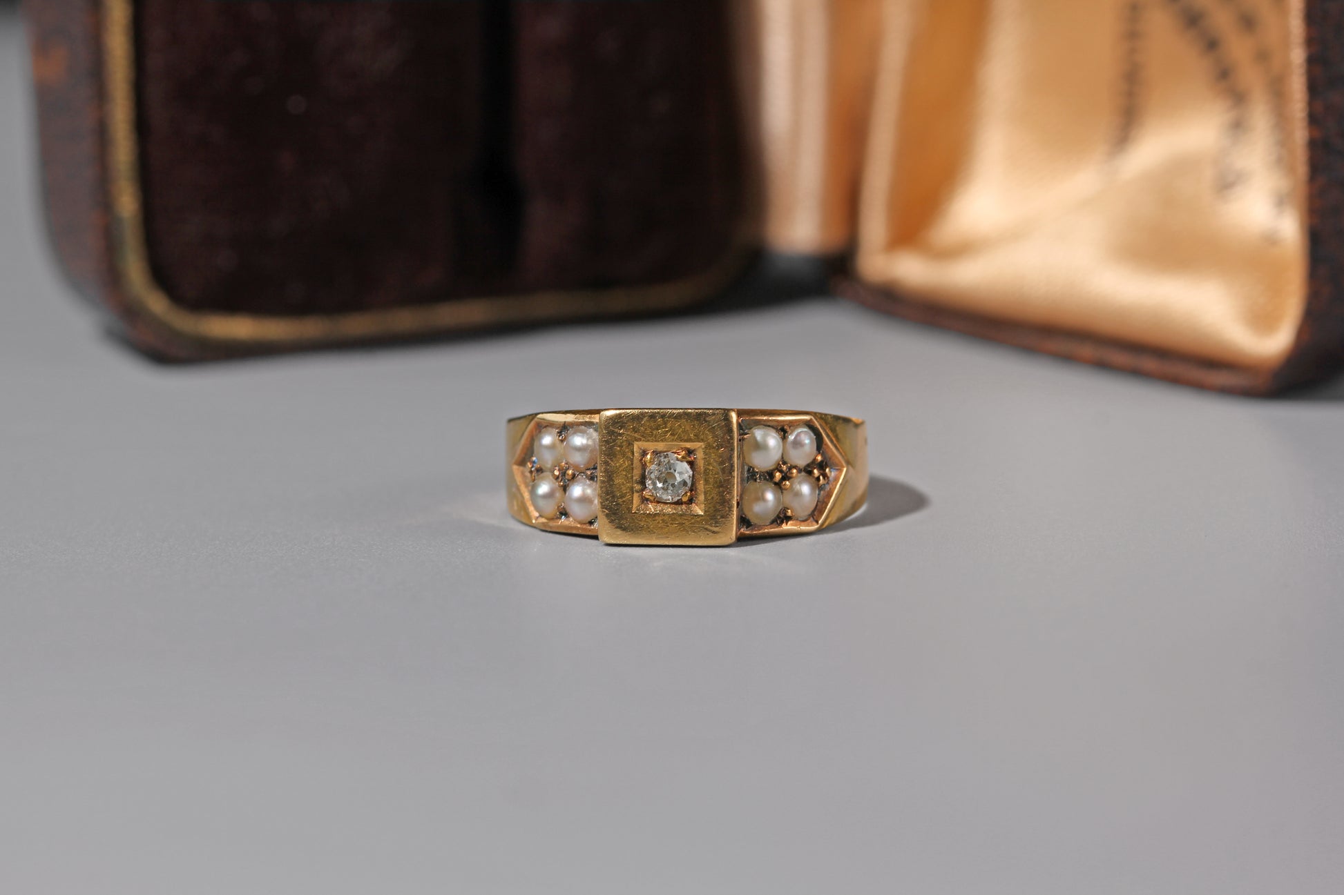 Antique 18ct gold band ring with central old cut diamond and split pearl shoulders
