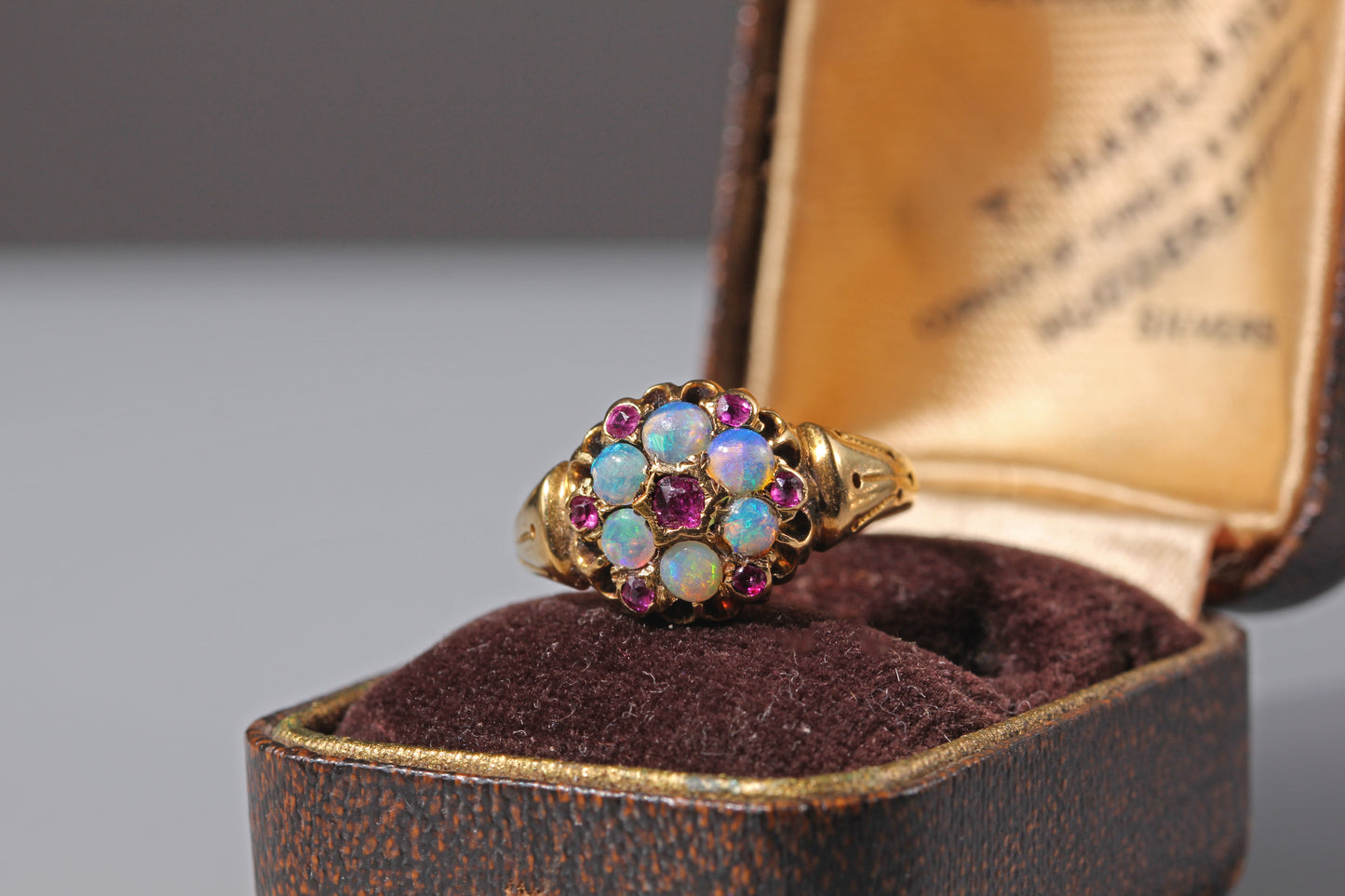Antique gold cluster ring with opals and amethysts on antique jewellery box