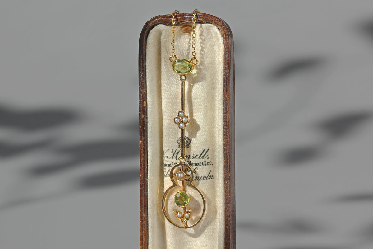 Antique Victorian pearl and peridot floral necklace in 15 carat gold, displayed in cream lined silk antique jewellery box box