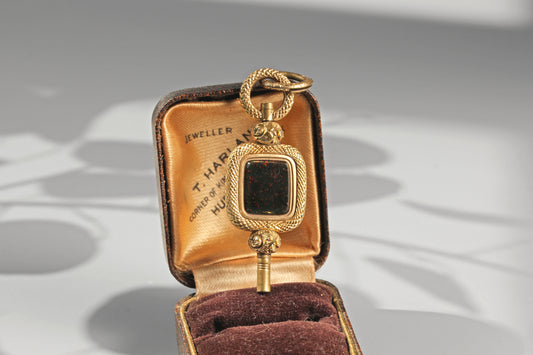 Antique bloodstone watch key pendant with ornate foliate detailing and split ring
