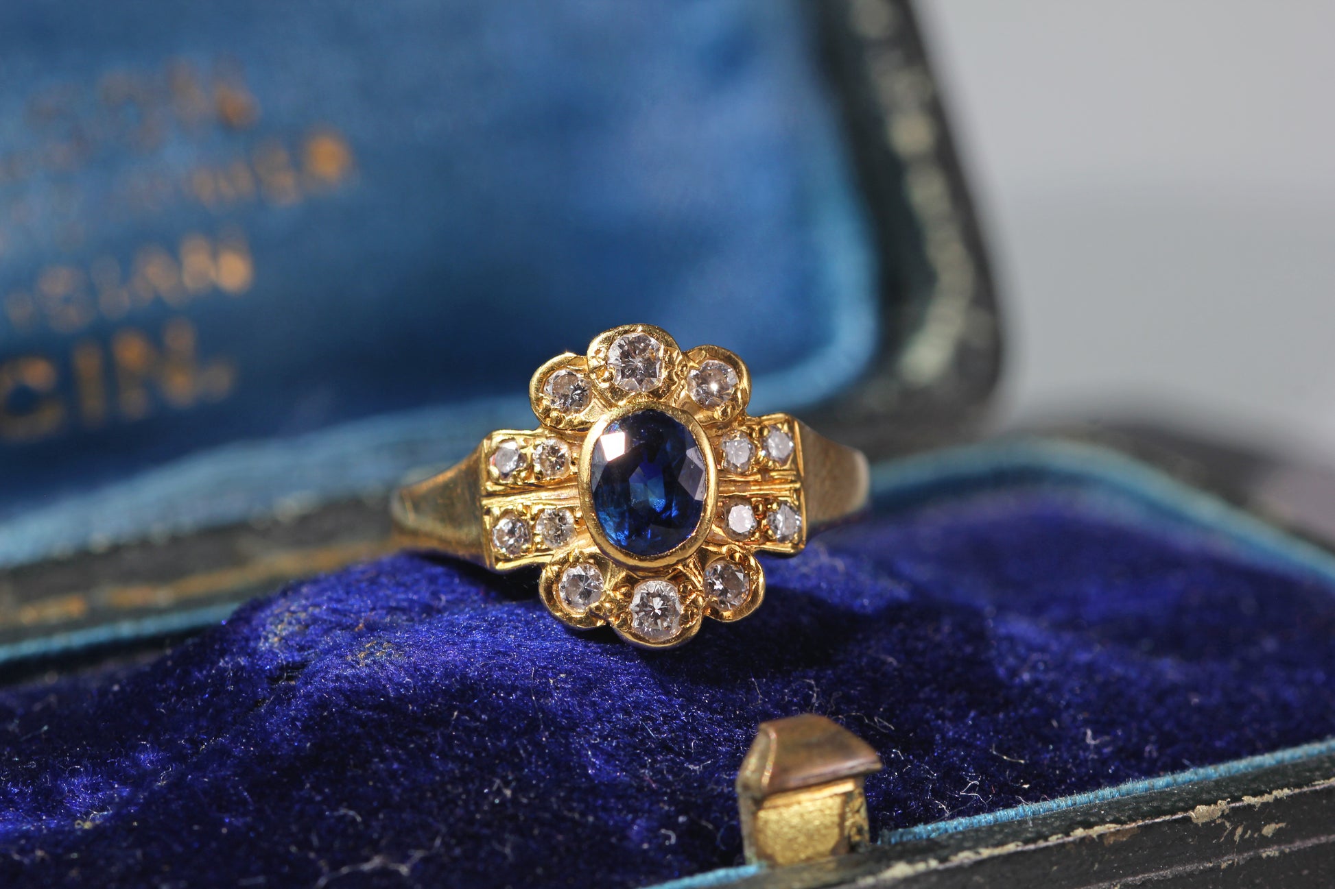 Front view of a vintage 18ct gold sapphire and diamond cluster ring
