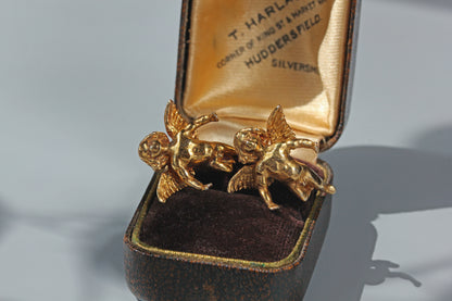 Close up of vintage angel earrings showing textured wings and sculptural detailing