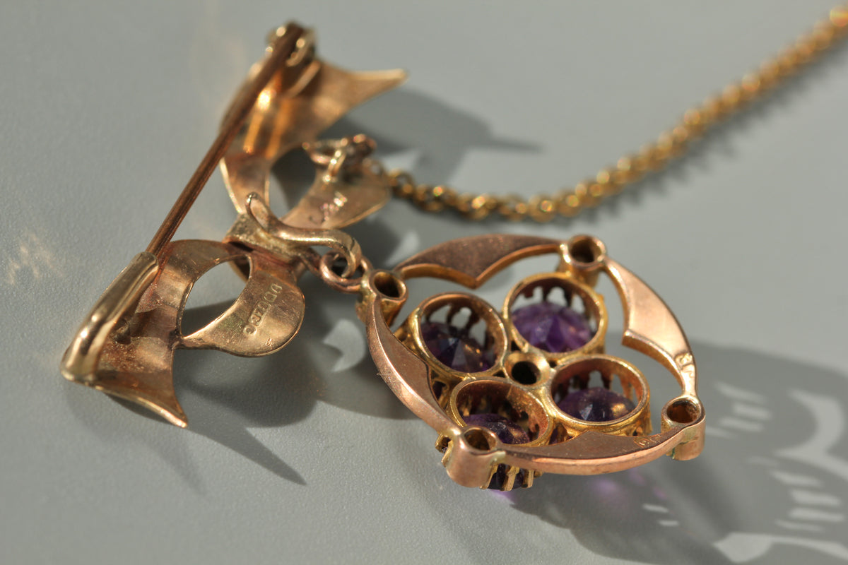 close up details of a vintage 9ct gold bow brooch and pendant, with clear gold hallmarks