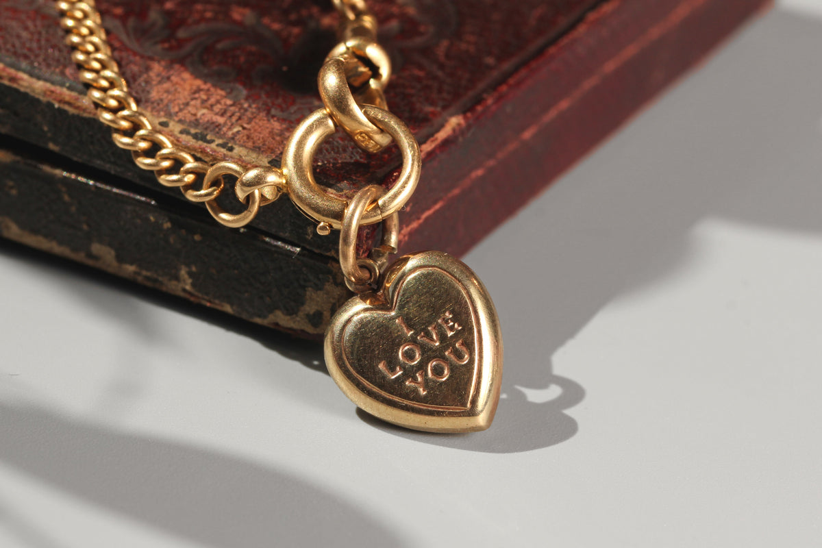 9ct gold vintage heart shaped charm engraved with 'I love you', displayed on Albert chain
