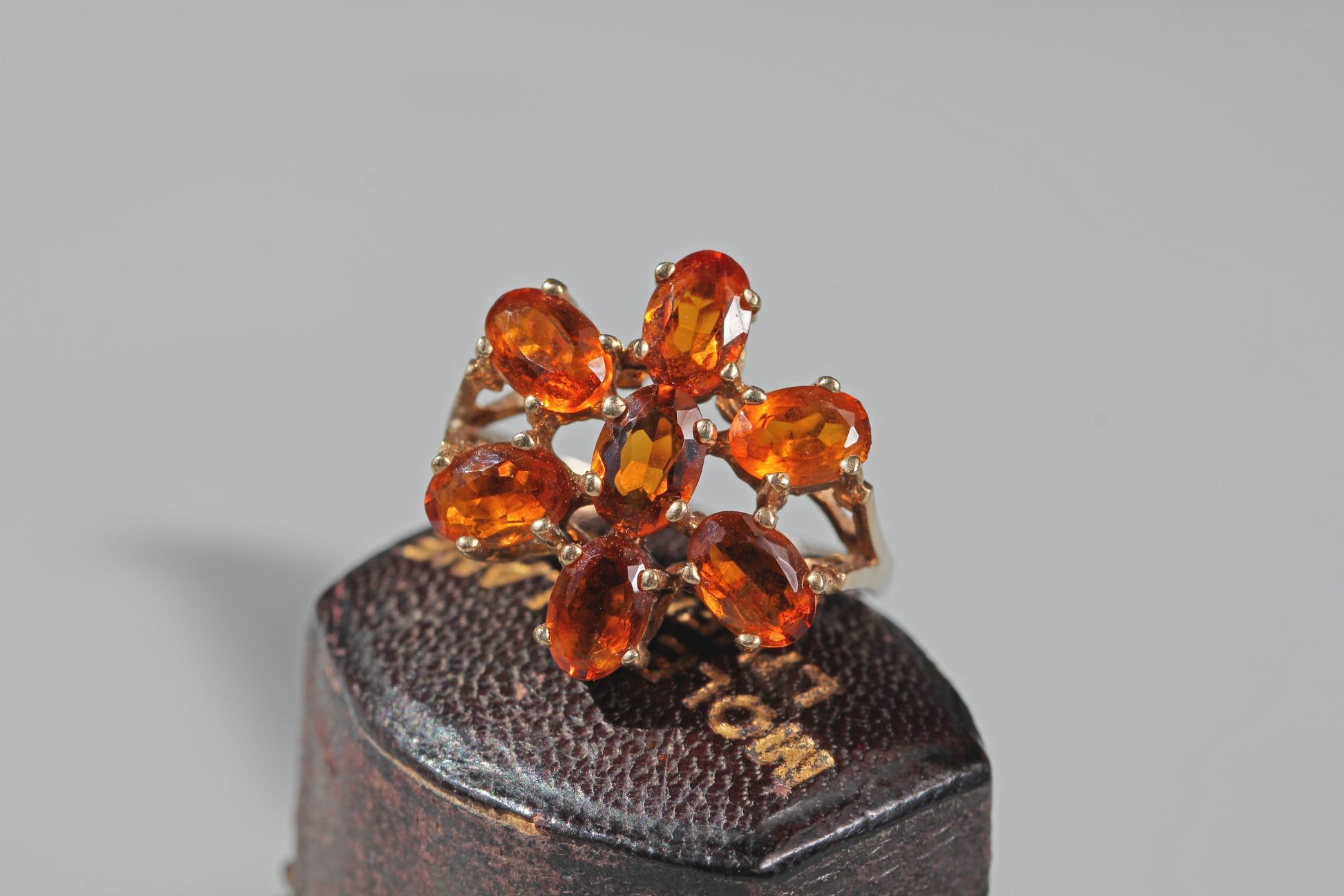 Vintage orange topaz statement ring with bright oval cut stones arranged as a flower cluster
