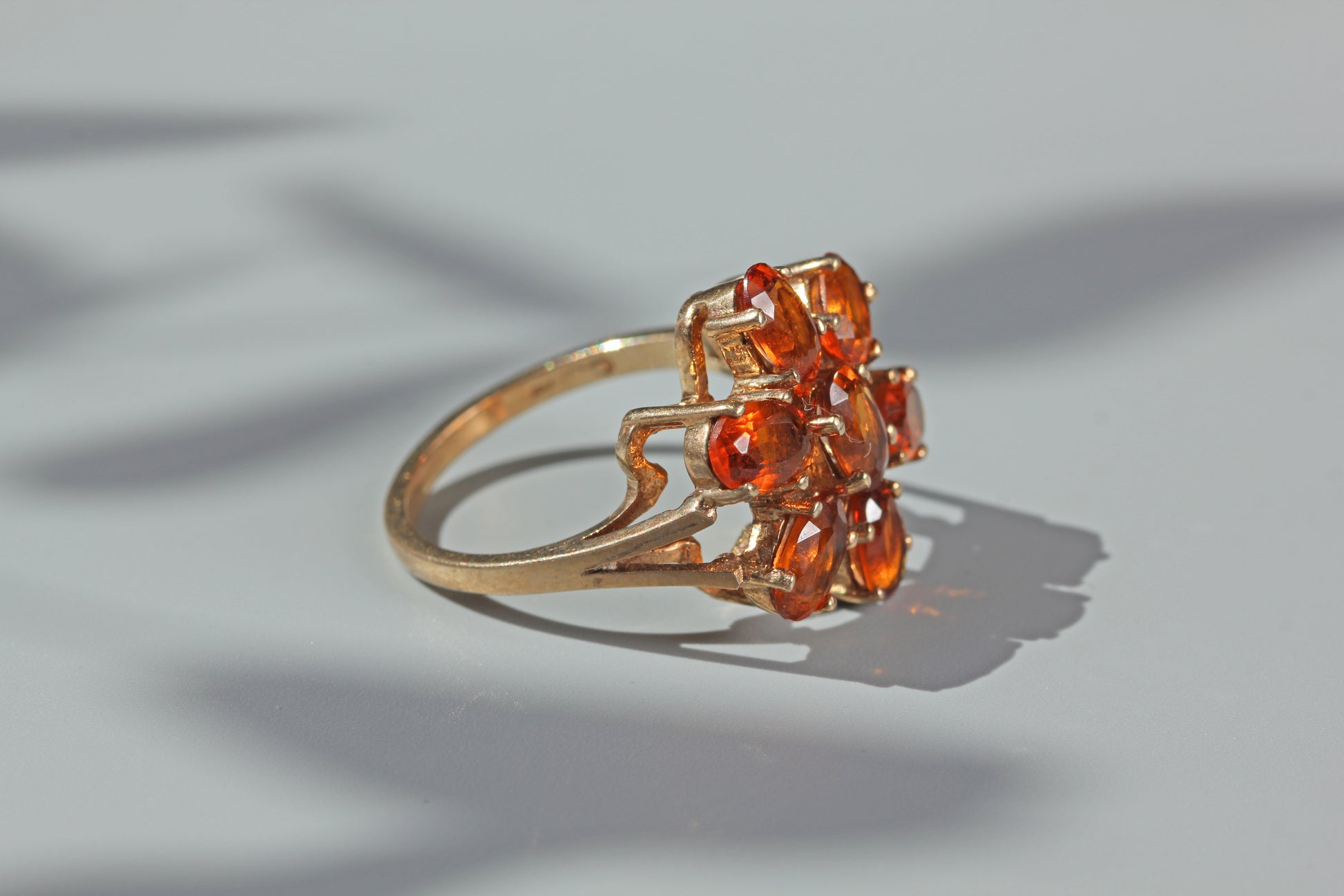 Side profile of vintage 9ct gold orange topaz cluster ring with open gallery setting
