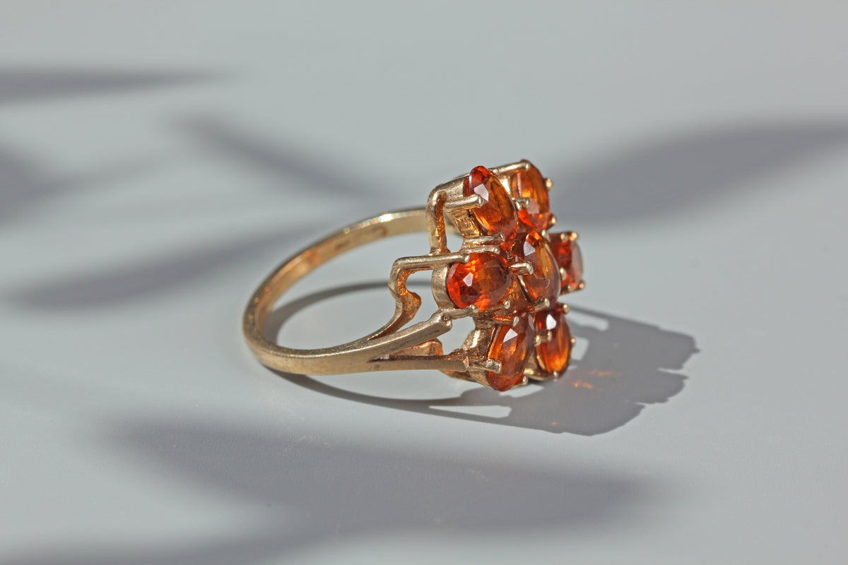 Side profile of vintage 9ct gold orange topaz cluster ring with open gallery setting
