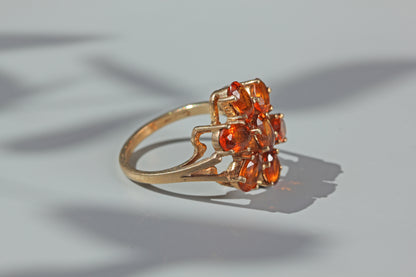 Side profile of vintage 9ct gold orange topaz cluster ring with open gallery setting
