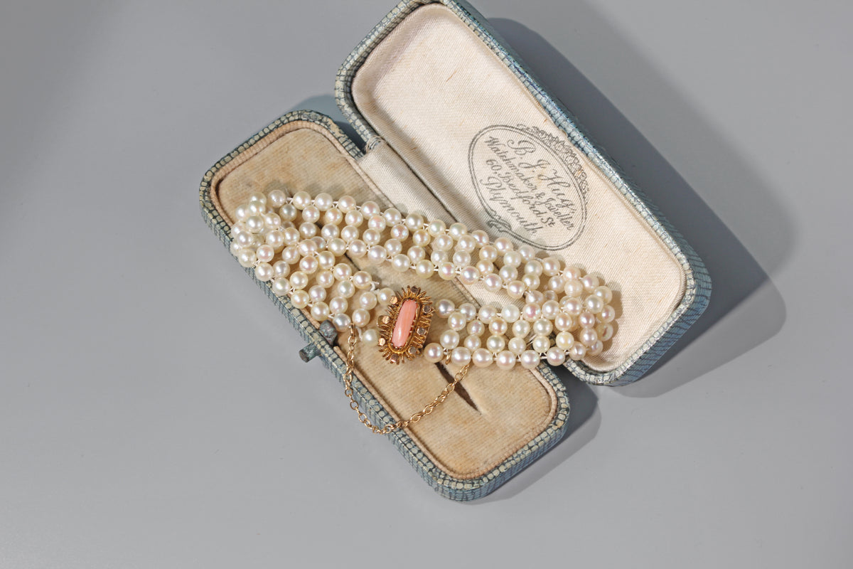 Vintage pearl bracelet displayed inside antique jewellery box
