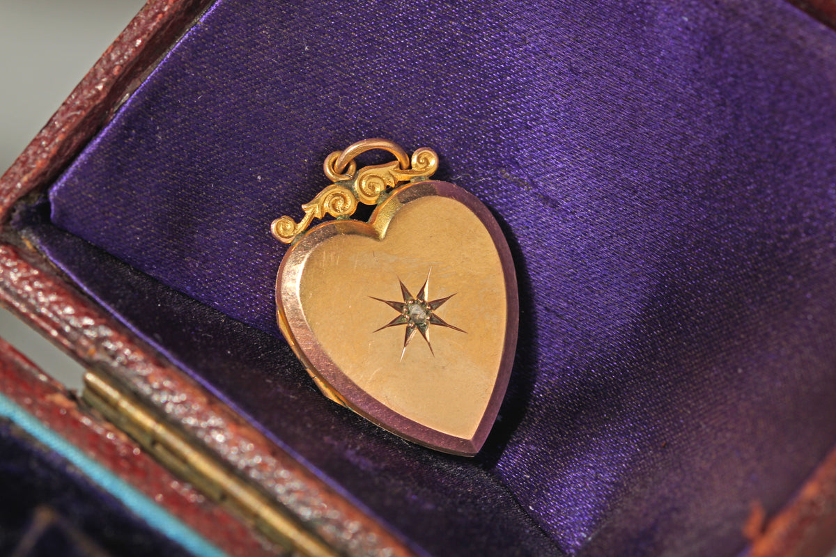 Vintage heart shaped locket in 9ct gold, with rose cut diamond set in a celestial, star shaped mount displayed on antique jewellery box